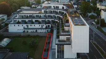 Moderne Wohnanlage mit begrünten Dächern und Balkonen aus der Vogelperspektive.