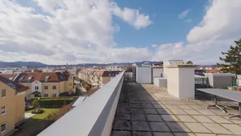 Große Dachterrasse mit weitem Blick über die umliegende Wohngegend und die Hügel im Hintergrund.
