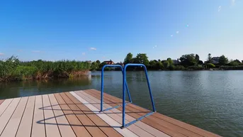 Privater Holzsteg mit Badeleiter bietet direkten Zugang zum See.