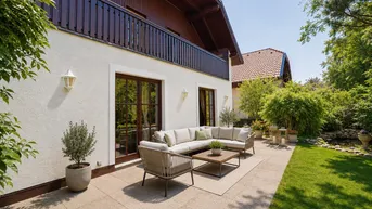 Große gepflasterte Terrasse mit bequemen Gartenmöbeln und Blick auf den grünen Gartenbereich.