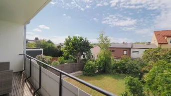 Balkon mit weitem Blick über den Garten und die umliegenden Häuser.