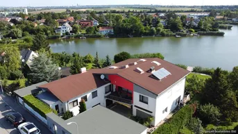 Luftaufnahme des modernen Hauses mit Satteldach, Balkon und Photovoltaikanlage.