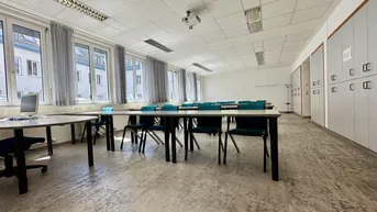 Heller Klassenraum mit großen Fenstern, viel Tageslicht, integrierten Schränken und strapazierfähigem Bodenbelag.
