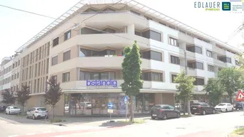 Moderne Wohnanlage mit Geschäften im Erdgeschoss und Balkonen an der Fassade.
