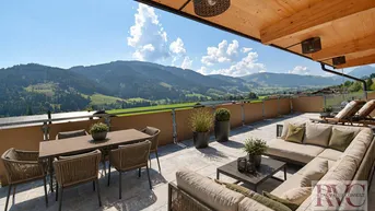 Geräumige Sonnenterrasse mit bequemen Loungemöbeln, Esstisch und atemberaubendem Bergblick.