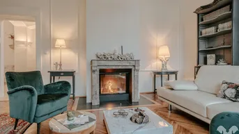 Elegantes Wohnzimmer mit Fischgrätparkett, Marmorkamin und stilvollen Möbeln.