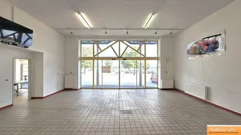 Großer, heller Verkaufsraum mit Fliesenboden, großen Fenstern und Blick auf den Parkplatz.
