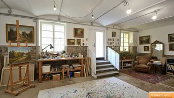 Geräumiges Künstleratelier mit hohen Decken, großen Fenstern und viel natürlichem Licht, ideal für kreative Arbeit.
