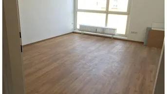 Helles Zimmer mit Laminatboden, großen Fenstern und Heizkörper, ideal als Wohn- oder Schlafzimmer.