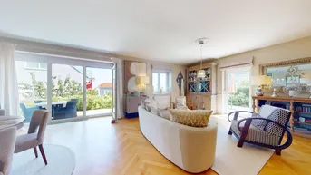 Helles Wohnzimmer mit Parkettboden, beigen Möbeln und Zugang zu einer Außenterrasse.
