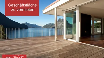 Große Holzterrasse mit beeindruckendem See- und Bergblick, verbunden mit einem Innenraum durch Glasschiebetüren.
