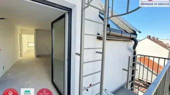 Blick von einem Balkon in einen unfertigen Innenraum mit Rohbauzustand und viel Tageslicht.