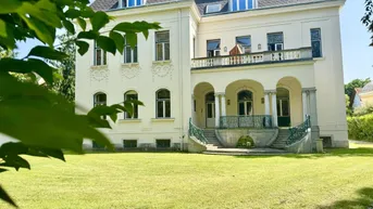Klassische Villa mit Mansarddach, großzügigem Garten und repräsentativem Eingangsbereich.