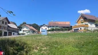 Blick auf ein sonniges Grundstück mit umliegenden Wohnhäusern und viel Grün in ländlicher Umgebung.