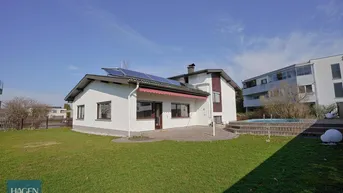 Großzügiger Gartenbereich mit Rasenfläche, Terrasse und kleinem Pool neben dem Haus.
