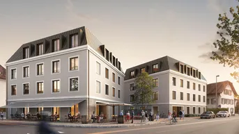 Moderne Wohn- und Geschäftshäuser mit Mansarddächern und belebter Außengastronomie an einer Straßenecke.