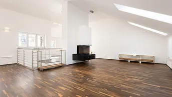 Großzügiger offener Wohnbereich im Dachgeschoss mit Kamin und Holzboden.