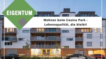 Modernes Mehrfamilienhaus mit Balkonen und großen Fenstern, umgeben von parkenden Autos.