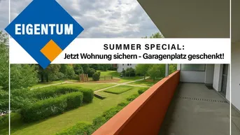 Balkon mit orangefarbener Brüstung und weitem Blick auf einen gepflegten grünen Innenhof mit Bäumen und Hecken.