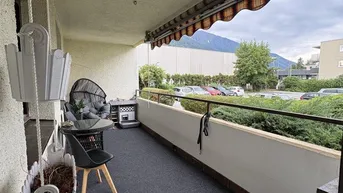 Gemütlicher Balkon mit Sitzgelegenheiten, Markise und Fernblick auf die Berge.