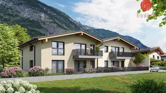 Moderne Doppelhaushälfte mit Balkonen und Bergblick, umgeben von grüner Landschaft und Blumenbeeten.