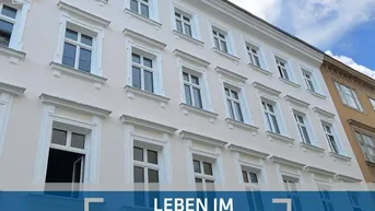 Klassische Fassade eines Wohngebäudes im Karmeliterviertel mit vielen Fenstern und Stuckelementen.