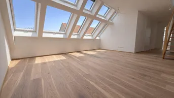 Helles Dachgeschosszimmer mit vielen Dachfenstern und neuem Holzparkettboden.