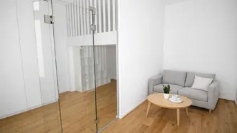 Modernes Wohnzimmer mit Holzfußboden, Sofa und einer offenen Galerie mit Glasabtrennung.