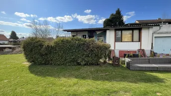 Großer Gartenbereich mit Rasenfläche, Hecke und Sitzgelegenheiten vor dem Haus.