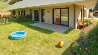 Gepflegter Gartenbereich mit Rasenfläche, kleiner Terrasse und Zugang zu den Wohnräumen.