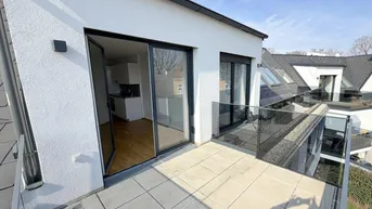 Geräumige Dachterrasse mit Fliesenboden und Glasgeländer, zugänglich vom Wohnbereich.