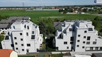 Luftaufnahme von zwei modernen Wohngebäuden mit Photovoltaikanlagen und grüner Umgebung.