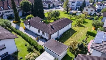 Luftaufnahme eines Einfamilienhauses mit großem Garten und umliegender Wohnbebauung.