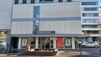 Moderne Geschäftsfassade mit großen Schaufenstern und dem Schriftzug "SEEBERGER" in der Stadt.