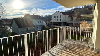Sonniger Balkon mit Holzboden und weitem Blick über die Umgebung.
