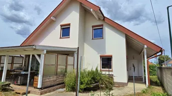 Vorderansicht des Hauses mit überdachtem Eingangsbereich und Terrasse.