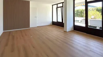 Helles Wohnzimmer mit modernem Holzlamellen-Akzent, Holzboden und Zugang zum Außenbereich.