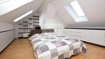 Helles Schlafzimmer im Dachgeschoss mit Holzboden, Einbauschränken und Dachfenstern.