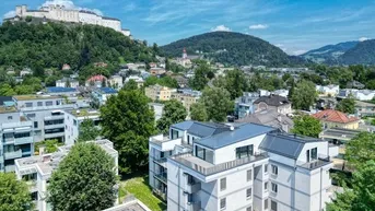 Luftaufnahme eines modernen Wohnkomplexes mit Blick auf die Festung Hohensalzburg und die Stadt.
