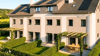 Moderne Reihenhäuser mit gepflegten Gärten, Pergolen und Solaranlagen auf dem Dach.
