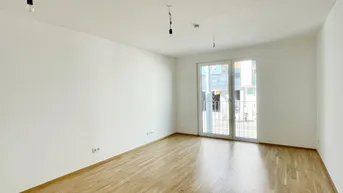 Heller Wohnraum mit Parkettboden und Zugang zu einem kleinen Balkon, ideal für entspannte Stunden.