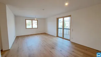 Helles Zimmer mit Holzboden und Zugang zu einem Balkon, ideal als Wohnbereich.