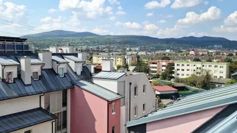 Panoramablick über die Stadt und die umliegenden Berge von der Dachterrasse.