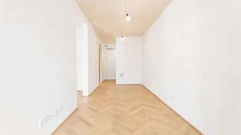 Heller Raum mit Fischgrätparkett und Holzdecke, bereit für individuelle Gestaltung.