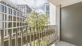 Balkon mit Blick auf einen begrünten Innenhof und die umliegenden Wohngebäude, bietet Ruhe.