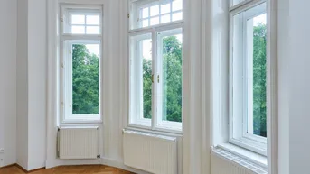Detailansicht der hohen Fenster mit Sprossen und Heizkörpern im Wohnbereich.
