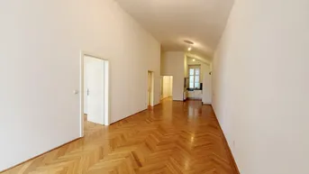 Geräumiger, heller Wohnbereich mit Fischgrätparkett und hohen Decken, bereit zur individuellen Gestaltung.