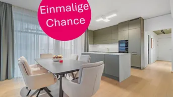 Moderne offene Küche mit Essbereich, Holzboden und großen Fenstern, die viel Licht hereinlassen.