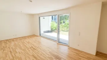 Geräumiges, leeres Zimmer mit hellem Parkettboden und großem Fenster mit Zugang zur Terrasse.