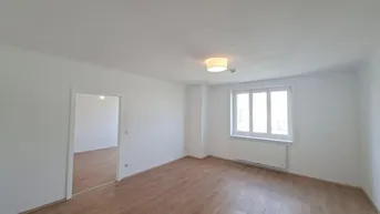 Helles, leeres Zimmer mit Parkettboden und Fenster, bereit zur individuellen Gestaltung.